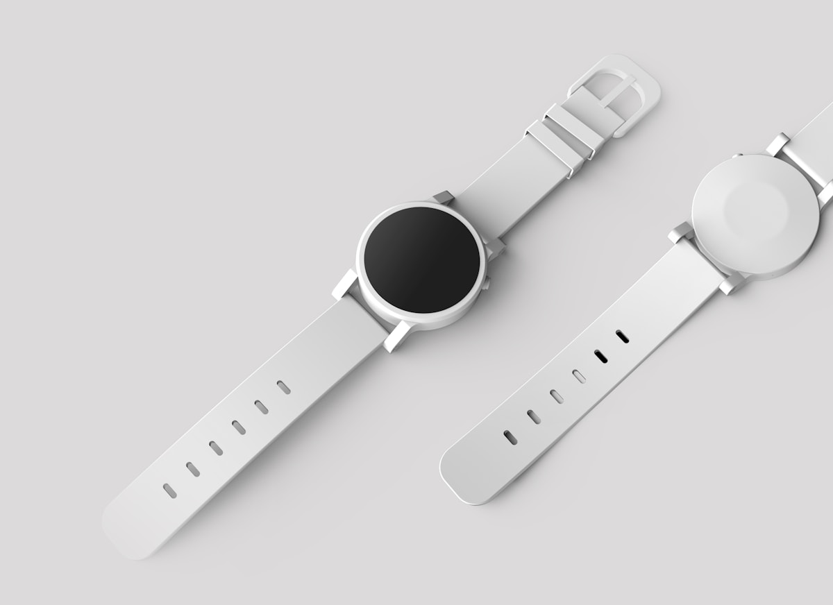Minimal white wristwatch on a pale background